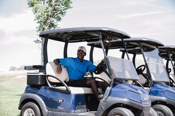 Man in golf cart surveying the links.